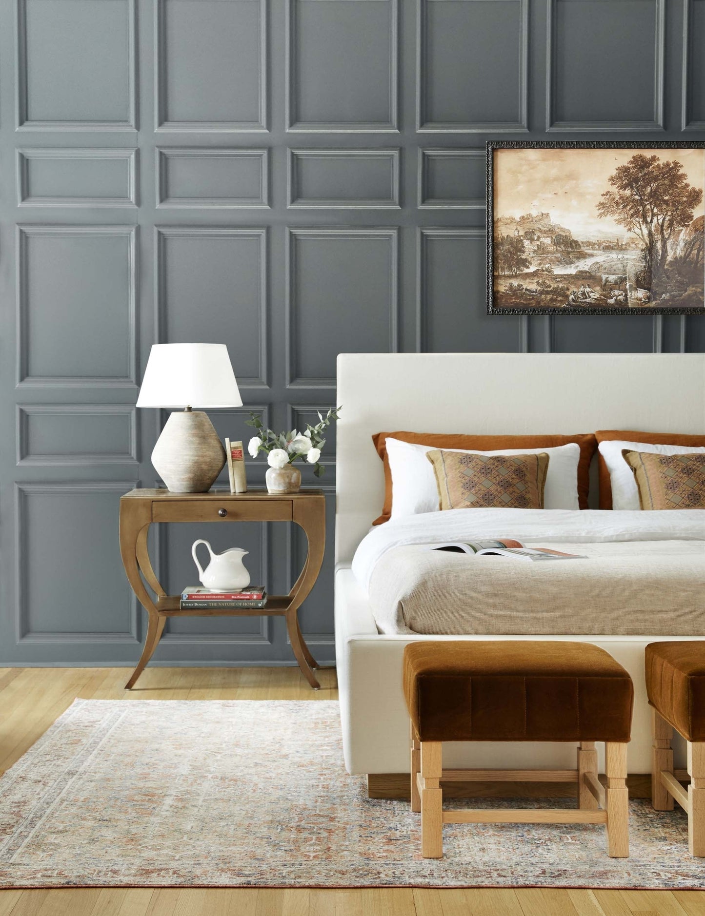 | The Este nightstand is in a bedroom with accented blue walls next to a natural linen framed bed