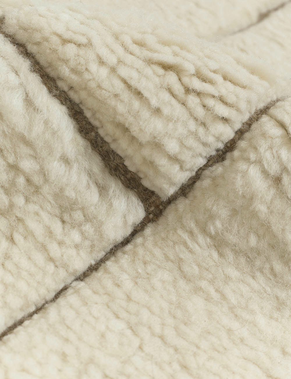 #size::6--x-9- #size::8--x-10- #size::9--x-12- #size::10--x-14- #size::12--x-15- | Close-up of the tufting on the Maleena cream hand-knotted wool and cotton area rug with abstract line tufting