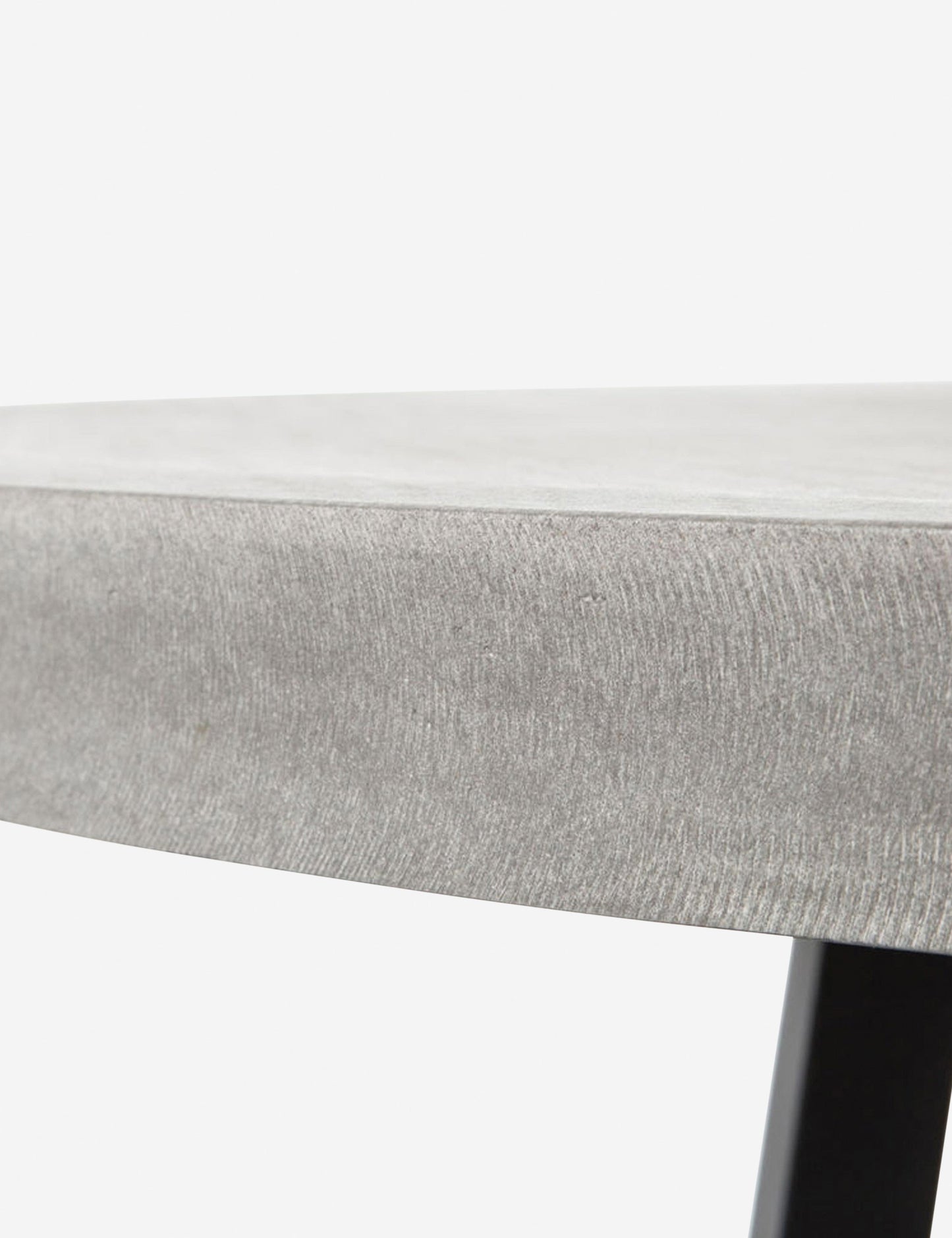 | Close-up view of the side of the tabletop on the Agatha indoor and outdoor dining table with lavastone top and black iron base