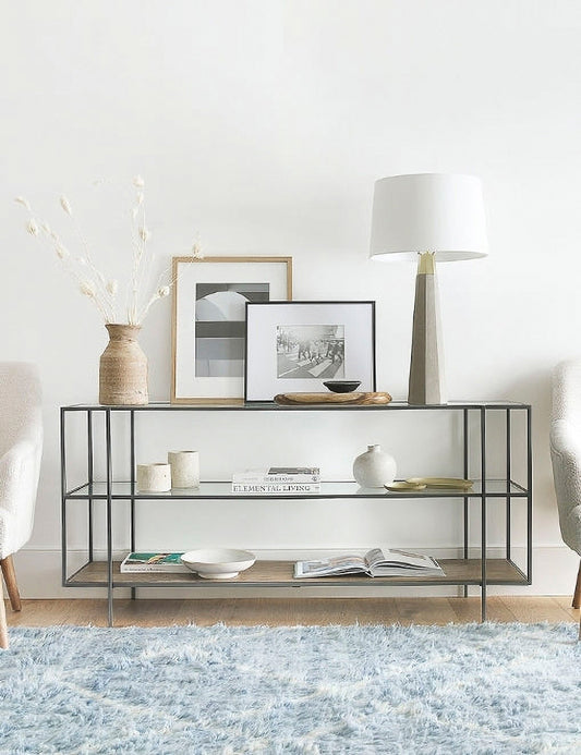 | The Asher console table filled with decorative objects sits against a white wall in a room with a blue rug