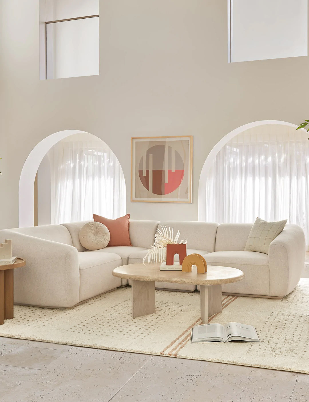 #size::6--x-9- #size::8--x-10- #size::9--x-12- #size::10--x-14- #size::12--x-15- | The Rina wool moroccan rug sits in a bright living room with a rounded white sofa, a light wooden coffee table, and orange and yellow sculptural decor