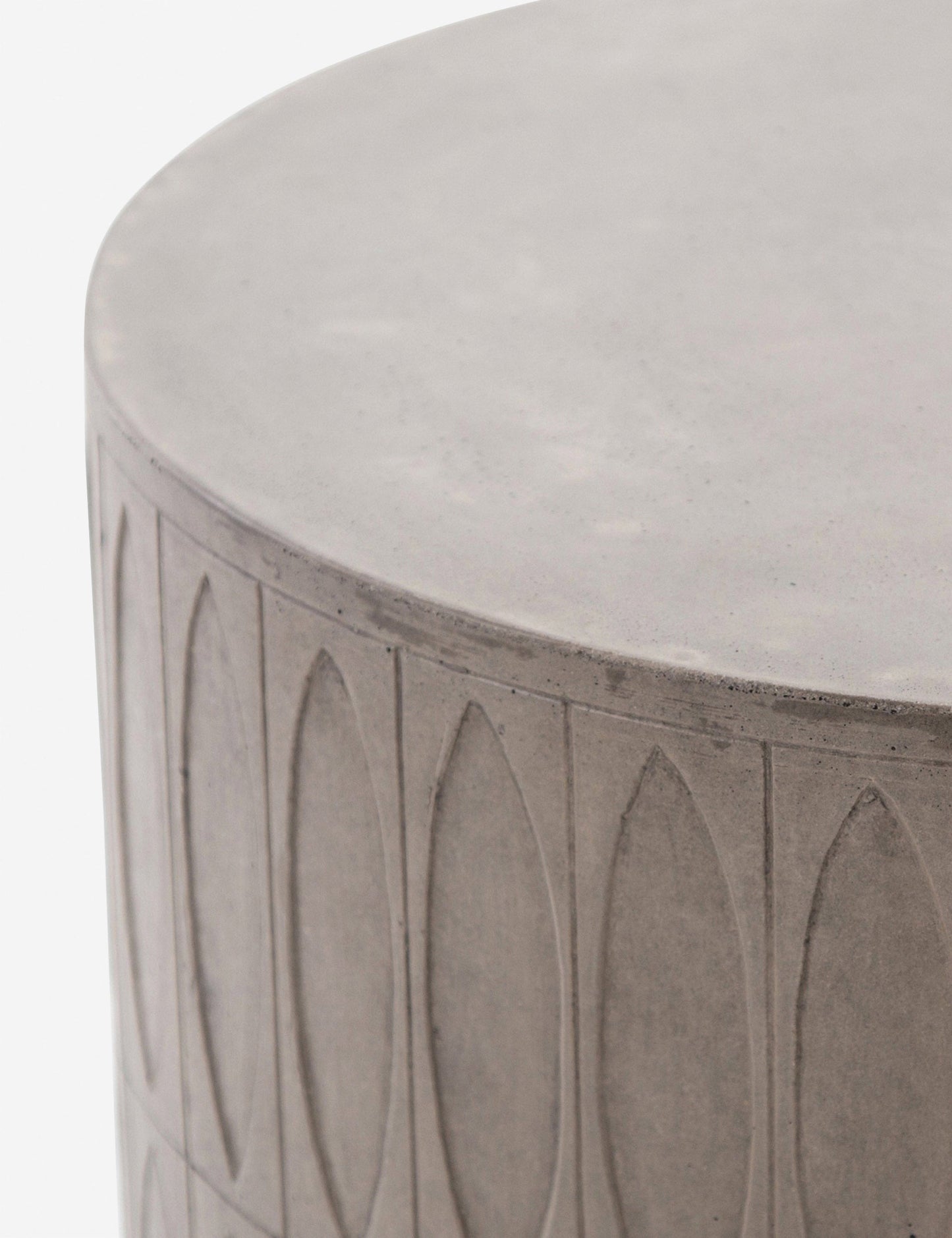 | Close-up of the upper half of the Glyn concrete indoor and outdoor side table with carved finish